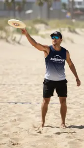 Beach Frisbee Player In Sleeveless Top Launching A Long