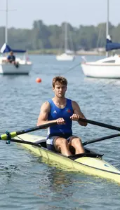 Coastal Rower In Sleeveless Racing Vest Pulling Oars Across
