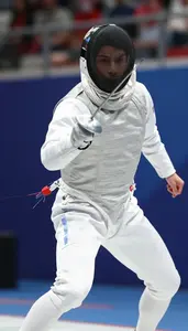 Fencer In White Protective Suit Lunging Forward With Foil