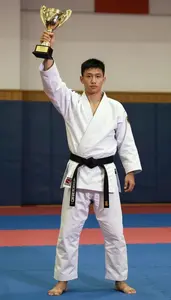 Indoor Martial Arts Champion In Traditional Uniform Raising