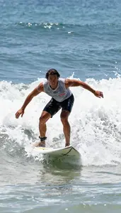 Open Coastal Paddle Surfer In Sleeveless Top Riding A Clean