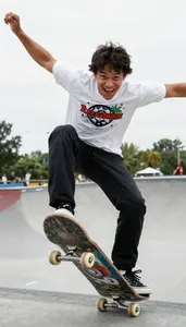 Skateboarder In Casual Sports Clothes Performing An Ollie