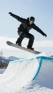 Snow Park Snowboarder In Insulated Jacket Performing A Grab