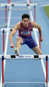 Track Hurdler In Compression Shorts Clearing A Barrier On A