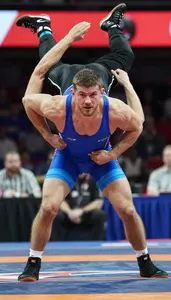 Wrestler In Blue Singlet Attempting A Reversal Move During