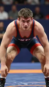 Wrestler In Singlet Grappling On Mat Intense Face Visible