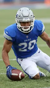 Action Shot Of A Football Defender In Blue Jersey Sliding To