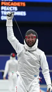 Fencer Celebrates A Point Mask In Hand Face Alight With Joy
