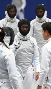 Fencer In A White Jacket And Mesh Mask Mask Under Arm Talks