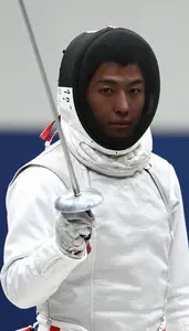 Fencer In A White Protective Jacket And Mask Mask Pushed Up