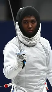 Fencer In A White Protective Jacket And Mask Mask Pushed Up