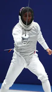 Fencer In White Protective Suit Lunging Forward With Foil