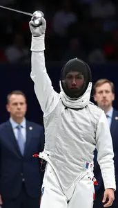 Fencer In A White Uniform And Mask Mask On Celebrates A