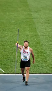 Javelin Thrower In A White Vest And Black Briefs Walks Back