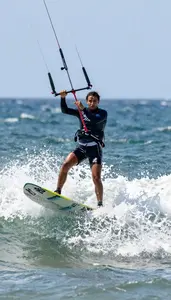 Kitesurfer In Harness And Board Shorts Launching High Above