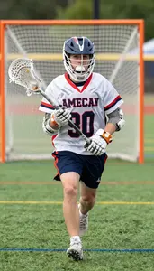 Lacrosse Player In A Jersey And Shorts Cradles The Ball In