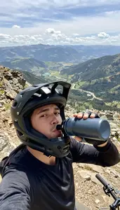 A Mountain Biker In A Full Face Helmet Pushed Back Takes A