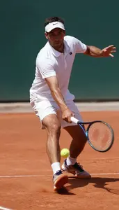Tennis Player In A Crisp Polo And Shorts Is Frozen Mid Slide