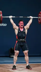 Weightlifter In A Singlet And Belt Exhales Sharply After A