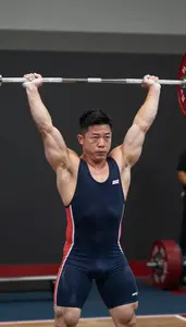 Weightlifter In A Tight Singlet Gripping The Barbell During