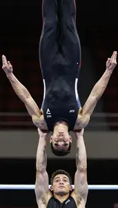 Acrobat In Stretch Costume And Strong Arms Holding A