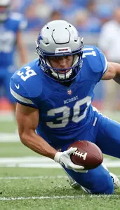 Action Shot Of A Football Defender In Blue Jersey Sliding To