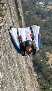 Base Jumper In Wingsuit And Flying Close To A Sheer Cliff