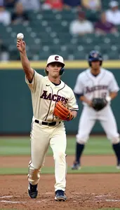 Baseball Fielder In A Cream Uniform And Cap Throws To First