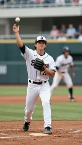 Baseball Fielder In A White Uniform And Cap Throws To First