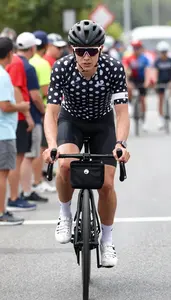 Cyclist In A Polka Dot Jersey And Black Rides Through A Feed