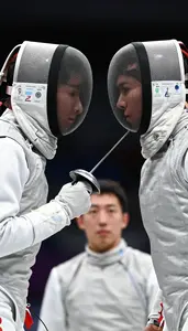 A Fencer And Opponent Face Off Both In White Masks Under