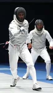 Fencer In A White Uniform Mask On Advances Blade Extended