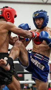 Muay Thai Fighter In Shorts And Wraps Delivering A Powerful