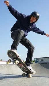 Skateboarder In A Navy Hoodie And Faded Black Jeans