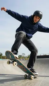 Skateboarder In A Navy Hoodie And Faded Black Jeans