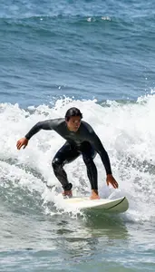 Surfer In A Steamer Wetsuit Paddles Hard To Catch A Late
