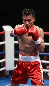 Boxer In Red Satin Shorts And Hand Wraps Spars In A Ring Jab