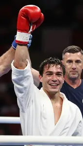 Boxer In A Robe And Gloves Has Their Hand Raised In Victory
