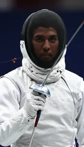 A Fencer In A White Protective Jacket And Mask Mask Pushed