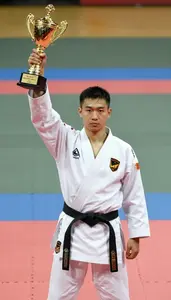 Indoor Martial Arts Champion In Traditional Uniform Raising