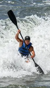 Rafter In And Life Jacket Paddling Hard Through A Massive