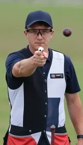 Shooter In Competition Vest And Specialized Glasses Breaking