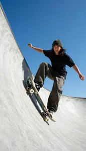 Skateboarder In A Beanie And Baggy Pants Rides A Bowl