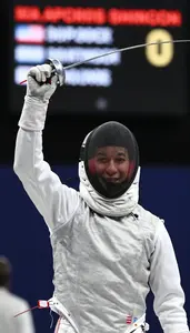 A Fencer Celebrates A Point Mask In Hand Face Alight With