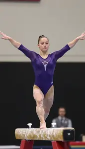 Gymnast In A Deep Purple Leotard Performs On The Balance