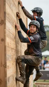 Obstacle Racer In Muddy Clothes And Team Colors Helping A