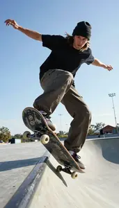 Skateboarder In A Beanie And Baggy Pants Grinds A Coping On