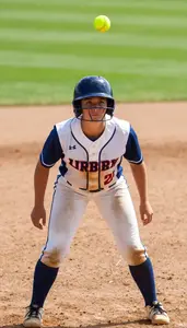 A Softball Player In A Dirt Stained Uniform And Helmet