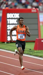 Sprinter In A Orange Vest And Black Briefs Finishes A Heat