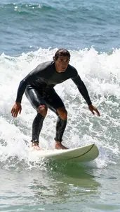 Surfer In A Wetsuit Paddles Into A Wave Popping Up Feet
